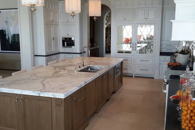 Example of a huge kitchen design in Orange County with an island