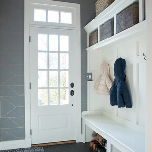 Foto di un ingresso con anticamera classico con pareti grigie, una porta singola, una porta bianca e pavimento nero