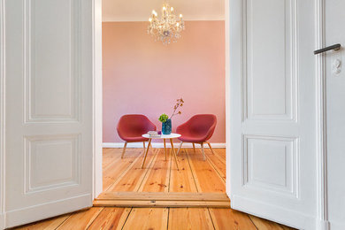 Mittelgroßes Nordisches Lesezimmer mit rosa Wandfarbe, hellem Holzboden und braunem Boden in Berlin