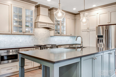 Open concept kitchen - large traditional l-shaped medium tone wood floor and brown floor open concept kitchen idea with an undermount sink, recessed-panel cabinets, white cabinets, quartz countertops, white backsplash, marble backsplash, stainless steel appliances and an island