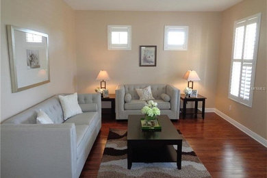 Living room - mid-sized transitional formal and enclosed dark wood floor and brown floor living room idea in Orlando with beige walls
