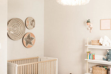 Mid-sized country nursery in Dallas with grey walls, dark hardwood floors and brown floor for girls.