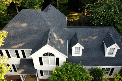 Modelo de fachada de casa blanca y negra tradicional de tamaño medio de dos plantas con revestimiento de vinilo y tejado de teja de madera