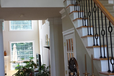 Staircase - large mediterranean wooden curved staircase idea in Charlotte with painted risers