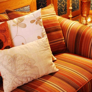 Geräumiges, Offenes Mediterranes Wohnzimmer mit blauer Wandfarbe, braunem Holzboden und verputztem Kaminsims in Orange County