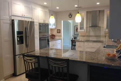 Mid-sized minimalist u-shaped marble floor kitchen photo in Miami with a single-bowl sink, flat-panel cabinets, beige cabinets, granite countertops, beige backsplash, ceramic backsplash and stainless steel appliances