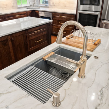 Close-up of custom white marble island with modern stainless steel sink station