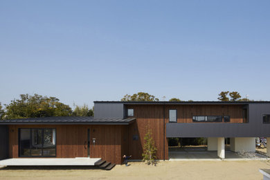Foto de fachada de casa gris y gris minimalista de tamaño medio de dos plantas con revestimiento de madera, tejado de un solo tendido, tejado de metal y panel y listón