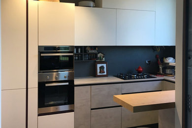 Ispirazione per una cucina contemporanea di medie dimensioni con lavello a doppia vasca, ante lisce, ante bianche, top in laminato, paraspruzzi grigio, paraspruzzi in gres porcellanato, elettrodomestici neri, pavimento in gres porcellanato, pavimento grigio e top grigio