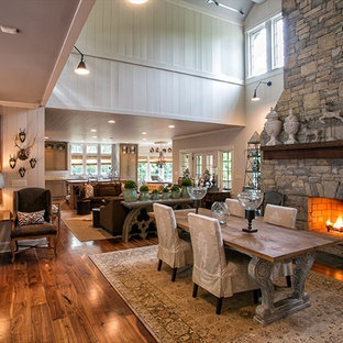 ハンティントンの広いトラディショナルスタイルのLDKの画像 (茶色い壁、濃色無垢フローリング、標準型暖炉、石材の暖炉まわり、茶色い床)
