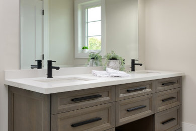 トロントにあるコンテンポラリースタイルのおしゃれな浴室 (茶色いキャビネット、白い洗面カウンター、洗面台2つ、造り付け洗面台) の写真