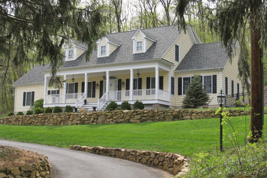 Mid-sized traditional yellow two-story vinyl exterior home idea in New York with a shingle roof