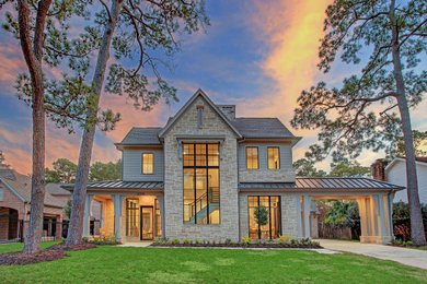 Huge trendy beige two-story stone house exterior photo in Houston with a mixed material roof and a brown roof