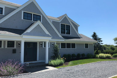 Example of a beach style gray two-story wood exterior home design in Providence with a shingle roof