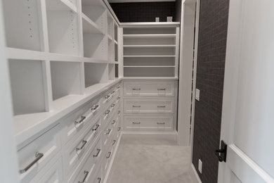 Inspiration for a large gender-neutral carpeted and gray floor walk-in closet remodel in Minneapolis with recessed-panel cabinets and white cabinets