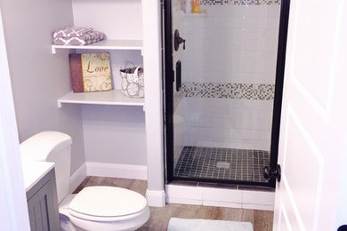Small transitional 3/4 white tile and subway tile ceramic tile alcove shower photo in Boise with shaker cabinets, medium tone wood cabinets, a two-piece toilet, gray walls, an integrated sink and solid surface countertops