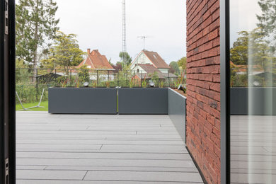 Imagen de terraza planta baja contemporánea de tamaño medio sin cubierta en patio lateral con barandilla de varios materiales