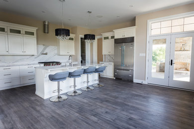 Open concept kitchen - mid-sized transitional l-shaped dark wood floor and brown floor open concept kitchen idea in Toronto with an undermount sink, shaker cabinets, white cabinets, marble countertops, white backsplash, marble backsplash, stainless steel appliances and an island