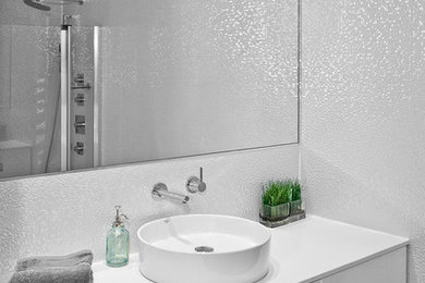 Photo of a contemporary bathroom in Chicago with a vessel sink, flat-panel cabinets, white cabinets, an alcove shower, white tile and mosaic tile.