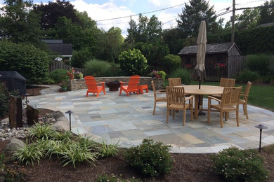 Inspiration for a large timeless backyard stone patio remodel in Philadelphia with a fire pit and no cover