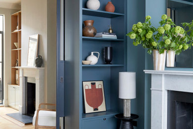 This is an example of a medium sized contemporary living room in Wiltshire with blue walls, a standard fireplace and a stone fireplace surround.