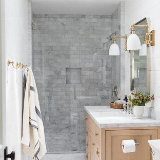 Idée de décoration pour une petite salle d'eau marine avec des portes de placard en bois clair, une douche d'angle, un carrelage gris, un mur blanc, un plan de toilette en marbre, une cabine de douche à porte battante et un plan de toilette blanc.