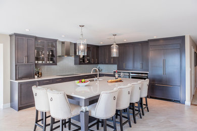 Transitional l-shaped eat-in kitchen photo in DC Metro with an undermount sink, recessed-panel cabinets, gray cabinets, quartzite countertops, gray backsplash, glass tile backsplash, stainless steel appliances and an island