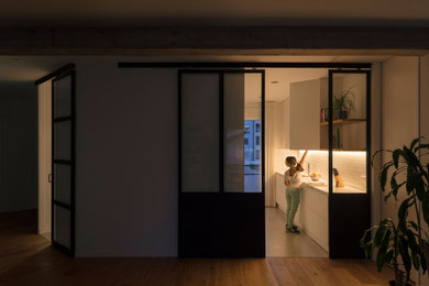 Modelo de cocina comedor contemporánea con fregadero de doble seno, armarios con paneles lisos, encimera de cuarzo compacto, salpicadero blanco, salpicadero de azulejos tipo metro, electrodomésticos con paneles, suelo de cemento, una isla, suelo gris, encimeras blancas y microcemento