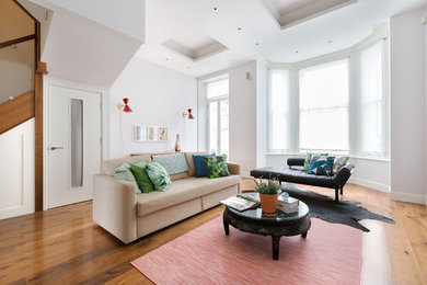 Inspiration for a modern open concept medium tone wood floor and brown floor living room remodel in London with no fireplace and a wall-mounted tv