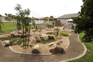 This is an example of a mid-sized southwestern full sun backyard stone pond in Phoenix for summer.