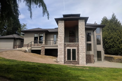 Example of a large classic gray three-story concrete fiberboard house exterior design in Portland with a hip roof and a shingle roof