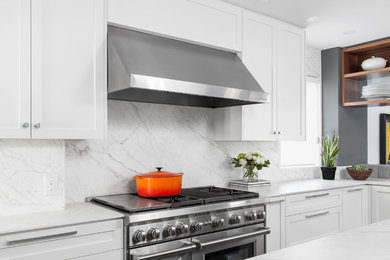Kitchen - mid-sized transitional u-shaped kitchen idea in Toronto with shaker cabinets, white cabinets, quartz countertops, white backsplash, stone slab backsplash, stainless steel appliances, an island and white countertops