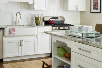Inspiration for a farmhouse u-shaped dark wood floor enclosed kitchen remodel in Denver with a farmhouse sink, granite countertops, white backsplash, subway tile backsplash, stainless steel appliances, a peninsula, white cabinets and shaker cabinets