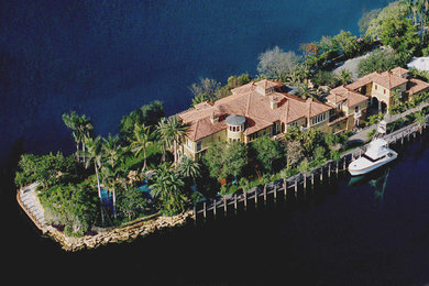 Example of a huge tuscan beige two-story stucco exterior home design in Miami