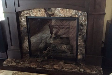 Example of a large arts and crafts carpeted family room design in Calgary with a standard fireplace and a stone fireplace