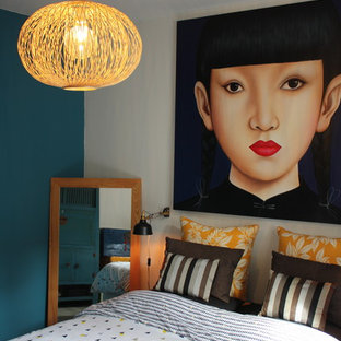 Immagine di una camera matrimoniale etnica di medie dimensioni con pareti blu e pavimento in laminato