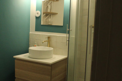 パリにあるお手頃価格の小さなミッドセンチュリースタイルのおしゃれなバスルーム (浴槽なし) (コーナー設置型シャワー、壁掛け式トイレ、青いタイル、セラミックタイル、青い壁、セラミックタイルの床、オーバーカウンターシンク、ラミネートカウンター、ターコイズの床、引戸のシャワー、白い洗面カウンター、洗面台1つ) の写真