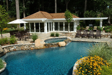Large elegant backyard stone and custom-shaped lap hot tub photo in Charlotte