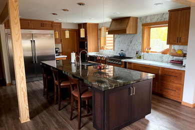 Large mountain style l-shaped vinyl floor and brown floor eat-in kitchen photo in Other with an undermount sink, shaker cabinets, light wood cabinets, quartzite countertops, white backsplash, porcelain backsplash, stainless steel appliances, an island and green countertops