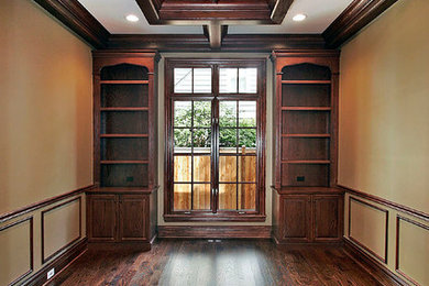 Example of a large classic dark wood floor home office library design in Chicago with brown walls