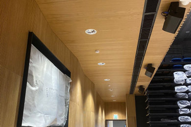Пример оригинального дизайна: большой открытый домашний кинотеатр в современном стиле с коричневыми стенами, полом из керамической плитки, телевизором на стене и бежевым полом