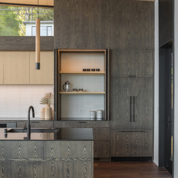 Full-height oak cabinetry with grain-matched panels, integrated refrigerator, an