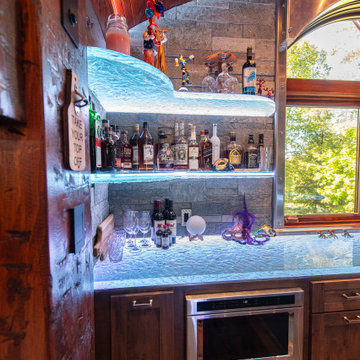 Glass private bar and glass stair treads inside a man cave in Michigan