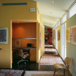 Ejemplo de despacho retro con paredes amarillas y suelo negro