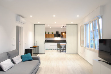 Foto di un soggiorno design di medie dimensioni e aperto con pareti bianche, pavimento in gres porcellanato e TV a parete