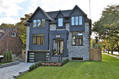 Inspiration for a large country two-storey grey house exterior in Toronto with stone veneer, a gable roof and a shingle roof.
