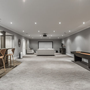 Photo of a large contemporary open plan home cinema in Indianapolis with grey walls, carpet, a projector screen and multi-coloured floors.
