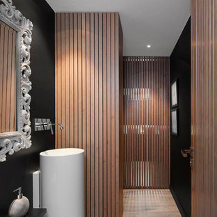 Immagine di una stanza da bagno moderna con lavabo a colonna e pareti nere