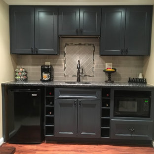 ワシントンD.C.の中サイズのトランジショナルスタイルのおしゃれなウェットバー (アンダーカウンターシンク、落し込みパネル扉のキャビネット、青いキャビネット、御影石カウンター、グレーのキッチンパネル、磁器タイルのキッチンパネル、クッションフロア、茶色い床) の写真