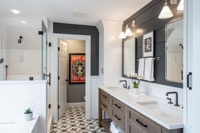 Large transitional master mosaic tile floor, multicolored floor, double-sink and shiplap wall alcove shower photo in Boston with recessed-panel cabinets, medium tone wood cabinets, black walls, an undermount sink, a hinged shower door, white countertops and a built-in vanity